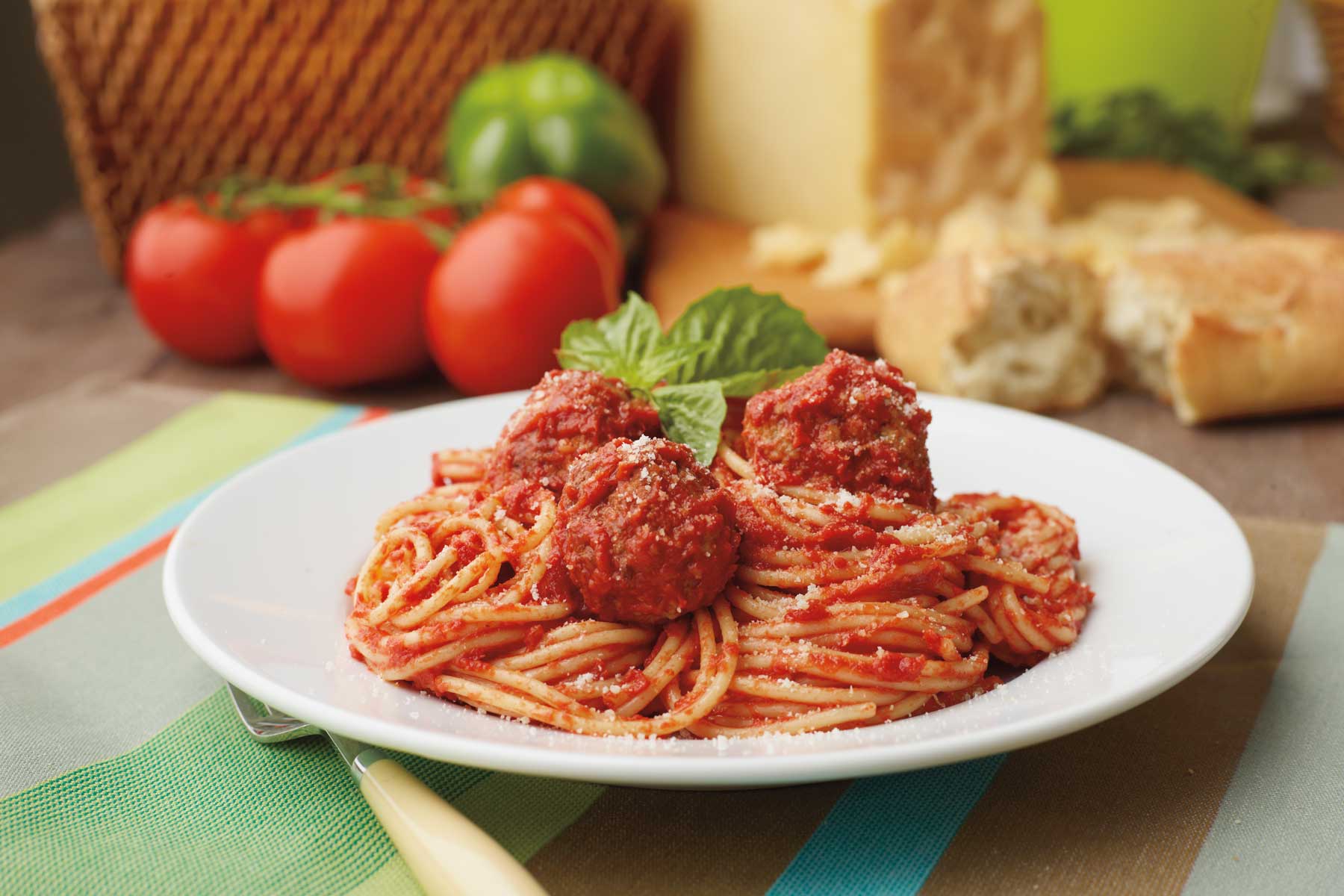 A closeup of spaghetti on a plate with parmesan cheese